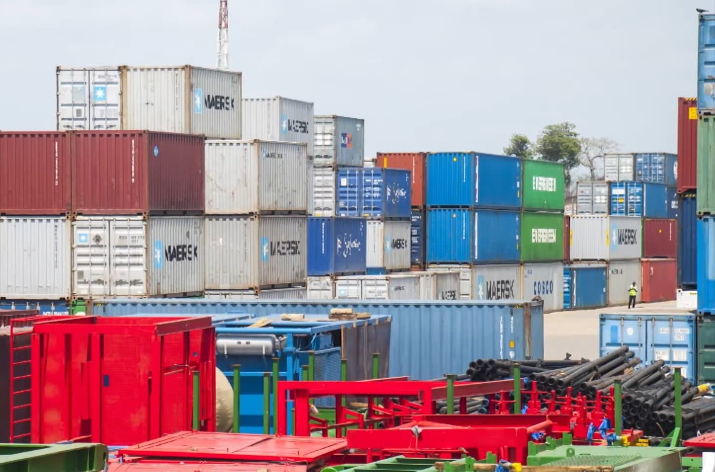 Stacked shipping containers at Focus CFS, Kipevu — Maersk, COSCO and Evergreen boxes rising several high, with project cargo and steel sections staged in the foreground.